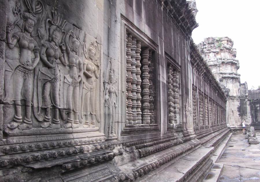 Stone wall inside Angkor Wat with relief figures and decorative windows