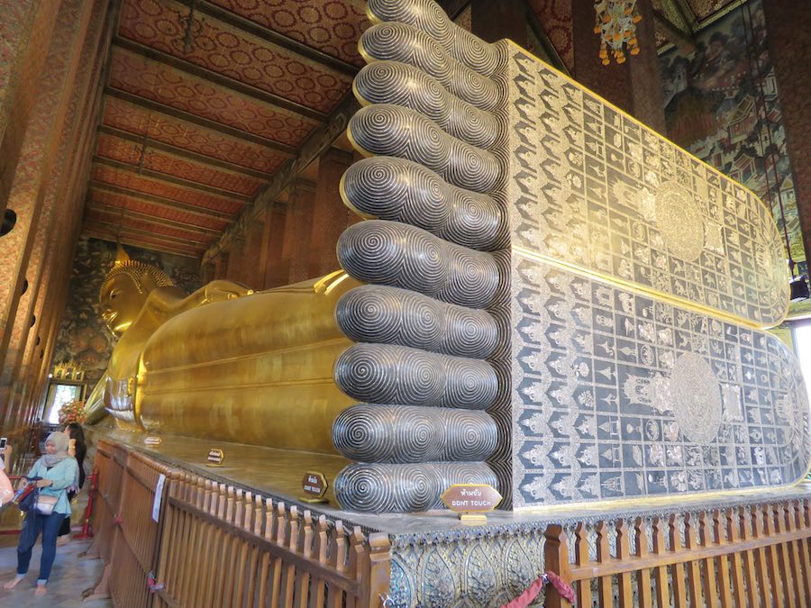 large reclining Buddha (in gold) with inscriptions on large feet